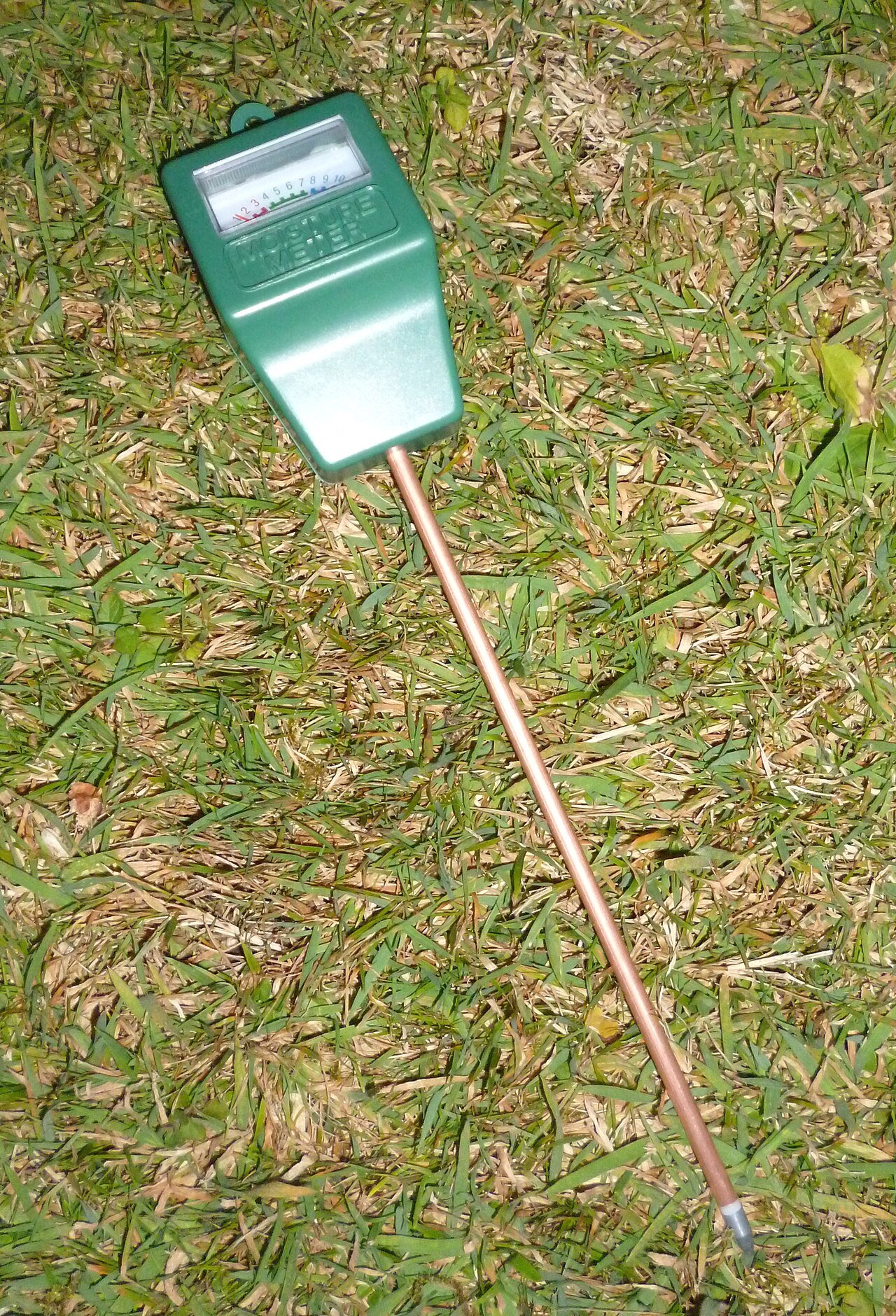 Capteur manuel d’humidité du sol posé sur de l’herbe