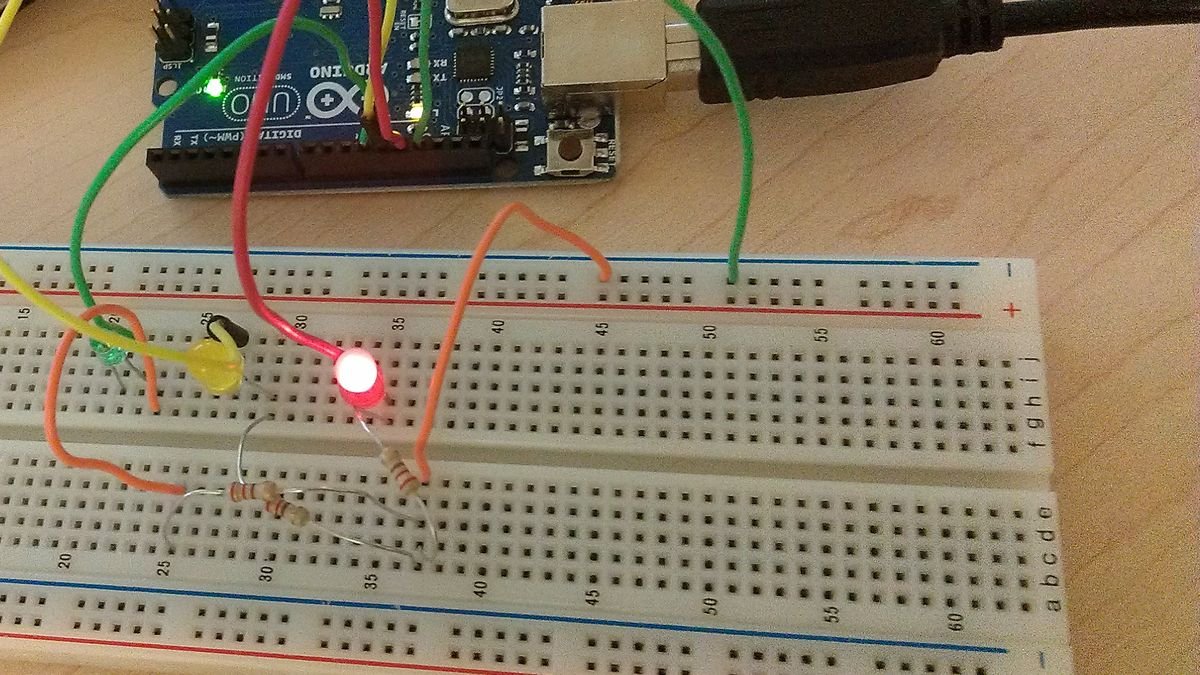Carte Arduino UNO reliée par des fils de couleur à une breadboard où trois LED rouge, jaune et verte sont branchées avec leurs résistances