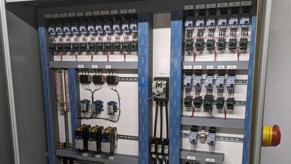 Intérieur d'une armoire électrique bien rangée : rails DIN, disjoncteurs, goulottes bleues et fils repérés par étiquettes