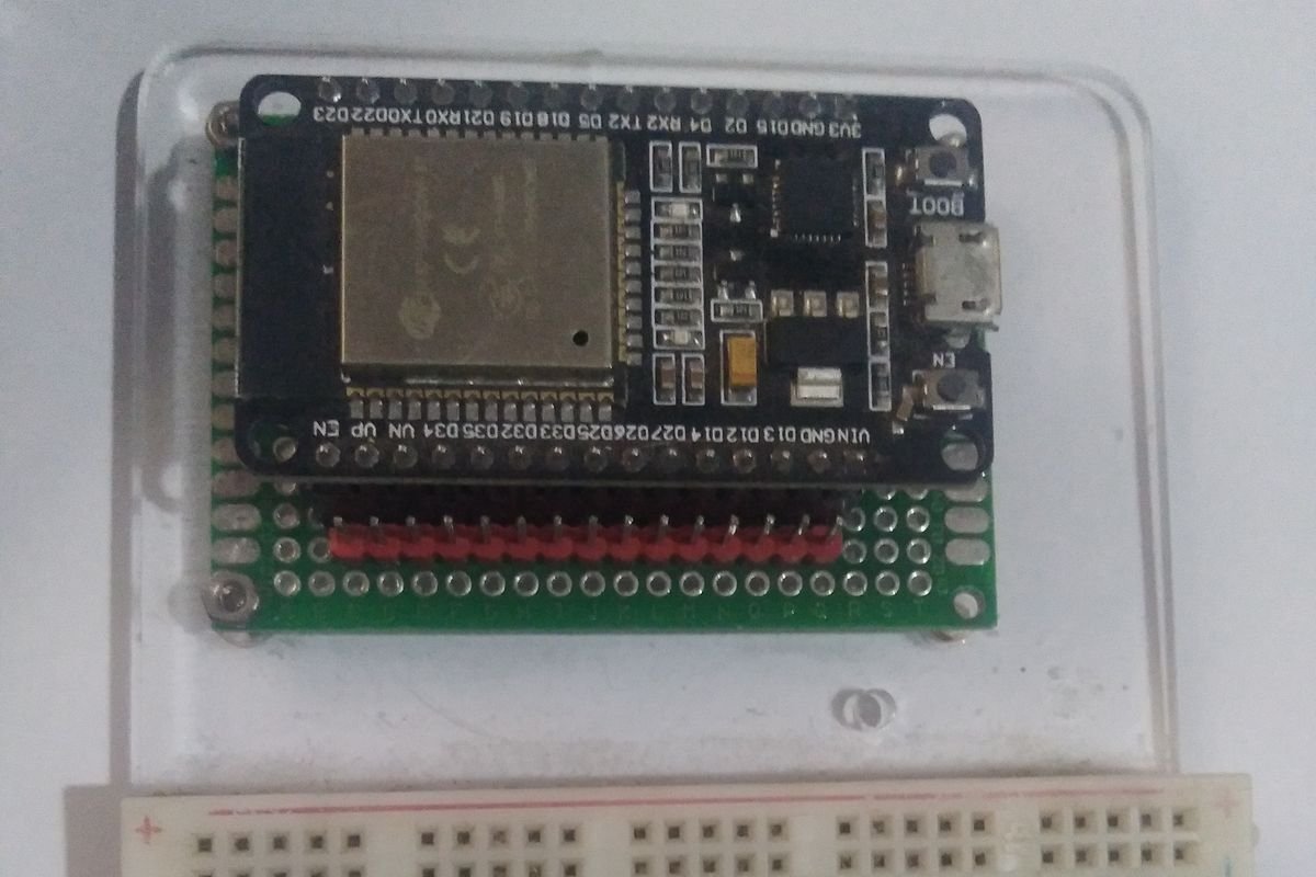 Carte de développement ESP32 noire avec son module Wi-Fi métallique, posée sur une plaque à trous au-dessus d’une breadboard